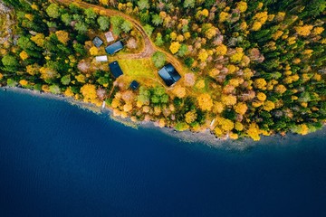 Wall Mural - Aerial view of cottage in autumn colors forest by blue lake in rural Finland