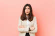 © Asier - Young brunette business woman against a pink background tired of a repetitive task.