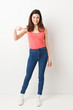 © Asier - Full body young woman on white background person pointing by hand to a shirt copy space, proud and confident