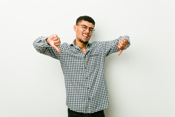 Wall Mural - Young hispanic man showing thumb down and expressing dislike.