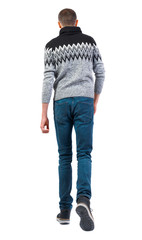 Canvas Print - Back view of going handsome man in winter sweater.