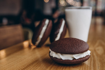 Poster - Close up Traditional chocolate and Pumpkin Whoopie pies filled made with vanilla cream cheese in cozy cafe background