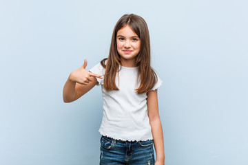 Sticker - Cute girl person pointing by hand to a shirt copy space, proud and confident