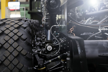 Close-up of new suspension system and shock absorber of car with wheel. Automotive part of atv off road. Mechanical engineering industry concept. Blurred background