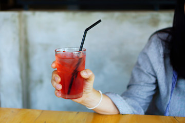 hand holding red cocktail in glass