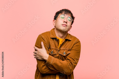 Cuadros en Lienzo Young chinese man wearing a jacket giving a hug