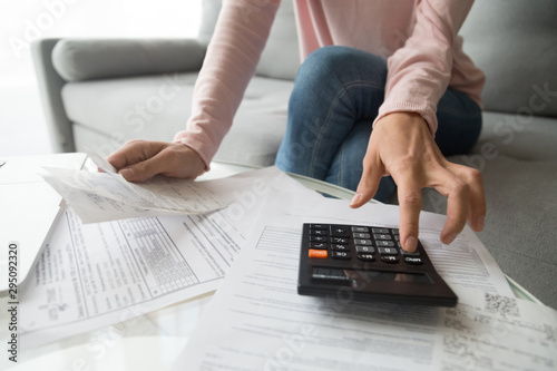 Cuadros en Lienzo Woman holding bills using calculator manage finances, close up view