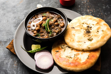 Wall Mural - Pindi Chole Kulche or roadside choley Kulcha popular in India and pakistan is a popular streetfood. It's a spicy Chickpea or chana curry served with Indian Flat Bread. selective focus