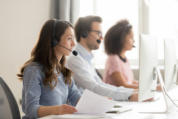 Wall Mural - call center worker holding paper talking with client use headset