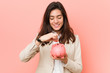 © Asier - Young caucasian woman holding a piggy bank