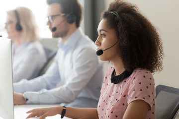 Wall Mural - side view african call center employee gives assistance distantly