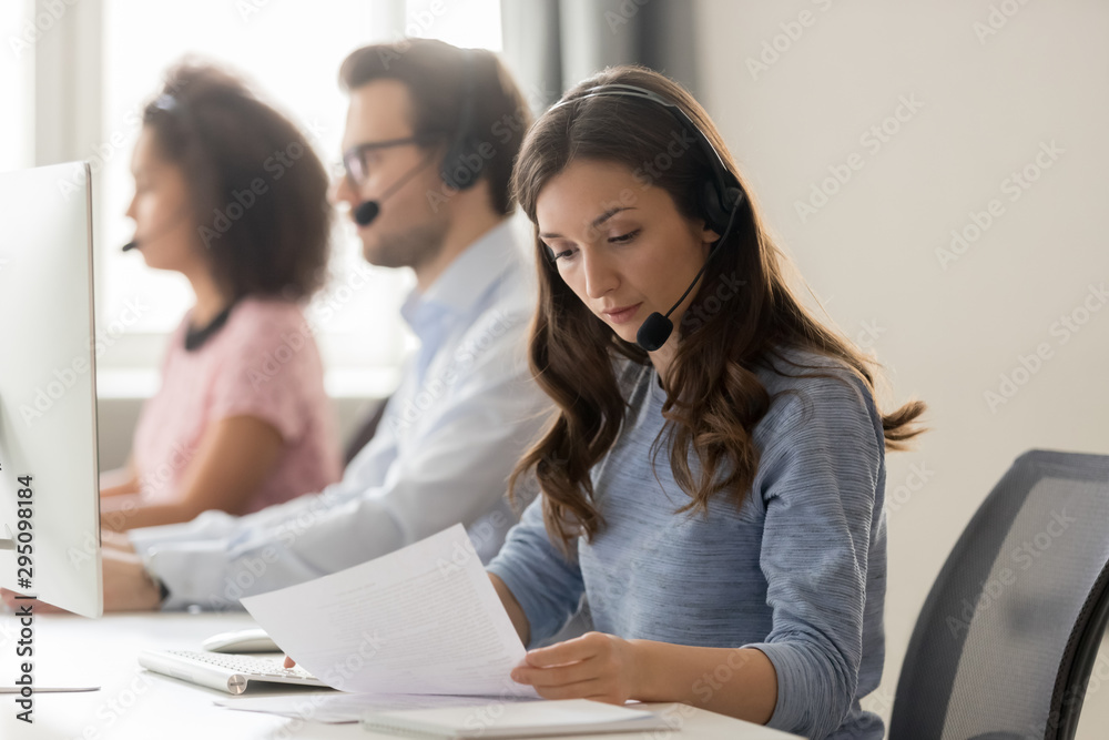 Customer support phone operator sitting at workplace holds read document - obrazy, fototapety, plakaty 
