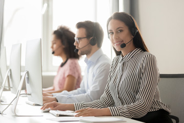 Canvas Print - Call center worker female working with colleagues looking at camera