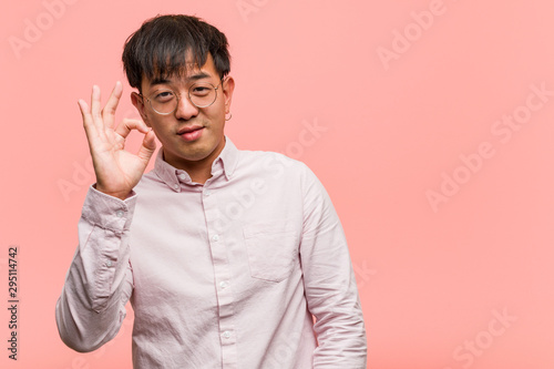Fotografía Young chinese man cheerful and confident doing ok gesture