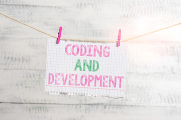 Writing note showing Coding And Development. Business concept for Programming Building simple assembly Programs Clothesline clothespin rectangle shaped paper reminder white wood desk