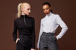 Two beautiful sexy woman long brunette blond hair glamour model wear pants and sweater work office style dress code accessory jewelry studio background fashion party meeting date makeup cosmetic.