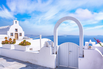 Traditional white architecture and door overlooking the Mediterranean sea in Oia Village on Santorini Island, Greece. Scenic travel background.