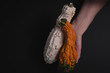 Beautiful decorative pumpkins in young woman's hand on a dark black faded background.White,orange warty pumpkins.Autumn harvest, Thanksgiving or Halloween concept. Low Key food photography.Copy space