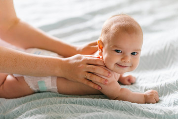 Massage for the baby. Four month old baby smiling doing gymnastics