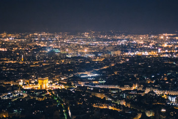 Aerial view of the Arc de Triomphe de l'Etoile (The Triumphal Arch) in Paris at night with traffic lights