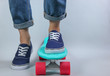 © splitov27 - Youth hipster concept. Female legs in jeans and sneakers on cruiser board in the studio on white background. Summer fun