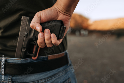 Fotografía Man holding hidden short gun in his hand.