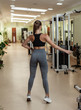 © splitov27 - Young slim sport woman bodybuilder in sportswear posing in the gym. Back view