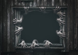 Fototapeta Na ścianę - Hands rising out from the old window ancient house, Halloween concept. Increased noise and grain effect.