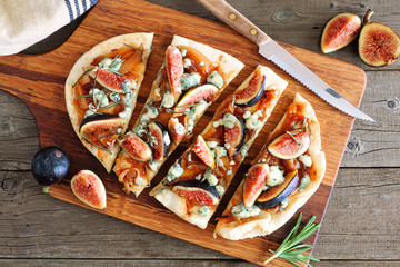 Poster - Fall flat bread pizza with figs, caramelized onions, blue cheese and rosemary. Overhead view table scene on a rustic wood background.
