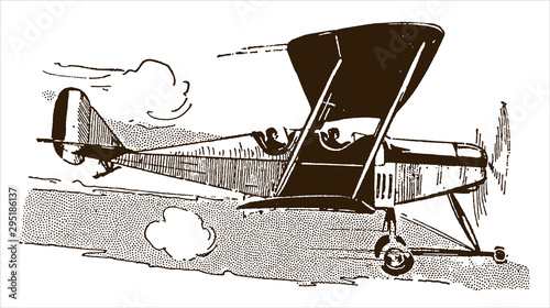 Fotografia Historical two-seater biplane flying in front of a cloudy sky