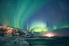 Wide Shot Of Aurora And The Starry Sky With Snowy Hills And The Lake