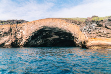 Beautiful Landscape Natural Rock Arch, On Cliff Edge Shoreline. Caves. Orange Rock With Green And Blue Ocean Background. Shot On Expedition Off Isabela Island, Galapagos, Ecuador.