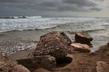 Beach with rocks on cloudy day