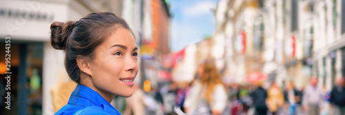 Fotomural Tourist travel Asian woman walking on city street looking at shops visiting Europe