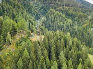 Wall Mural - Aerial view of power line and pylon in alpine valley of Goms in Switzerland. Power grid through alps. 