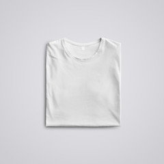  Folded  blank T-shirt  with shadows  lying on the studio background.