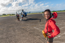 Helicopter Tour Asian Tourist Walking On Airport Tarmac Going To Tourism Excursion Summer Travel Vacation Leisure Activity. Woman Looking At Camera Excited Candid.