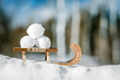 canvas print picture - Kleiner Schlitten aus Holz im Schnee, drei Schneebälle
