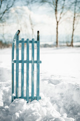 Schlitten steckt im Schnee, Landschaft im Hintergrund, Konzept Winterferien und Urlaub