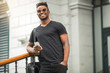 © Alexandr - handsome young african man in a t-shirt with a phone in his hand