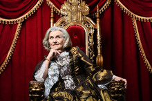 Portrait Of A Surprised Beautiful Senior Queen On Throne