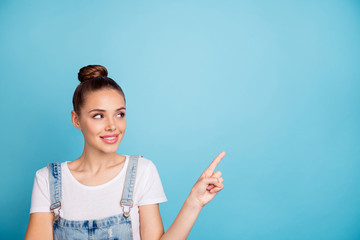 Canvas Print - Portrait of attractive girl looking at ads wearing white t-shirt denim jeans overalls isolated over blue background