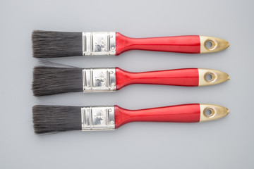 Red handle paint brush on grey background