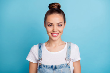 Poster - Close up photo of charming lady looking with toothy smile wearing white t-shirt denim jeans overalls isolated over blue background