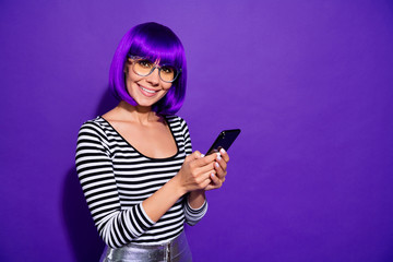 Poster - Portrait of cute person with violet fringe holding modern technology looking isolated over purple background