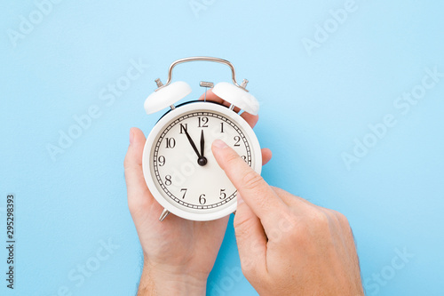 Photographie Man hand holding white alarm clock