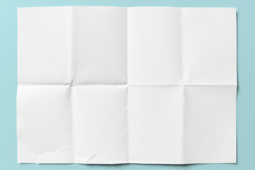 white paper folded in eight, isolated on light blue