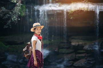 Wall Mural - beautiful woman standing in front of waterfall in rainforest