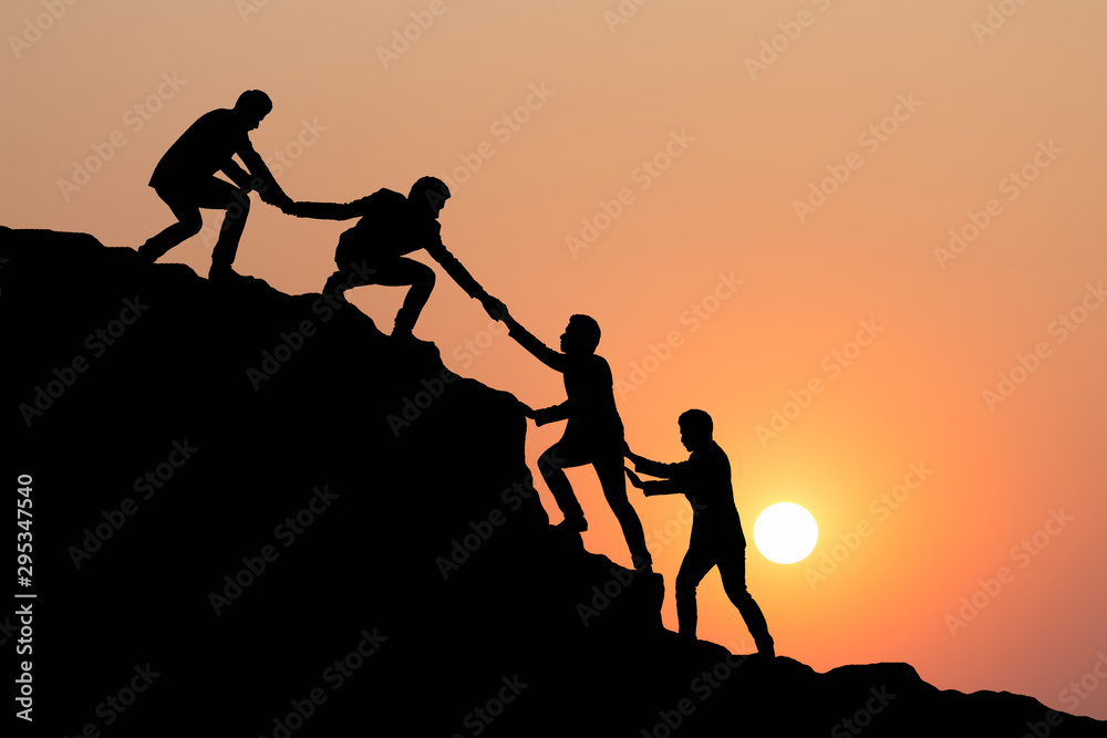 Silhouette of people helping each other hike up a mountain at sunset background. Teamwork, success and goal concept. - obrazy, fototapety, plakaty 