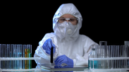Wall Mural - Worker of laboratory showing sample of toxic ground before camera, pollution
